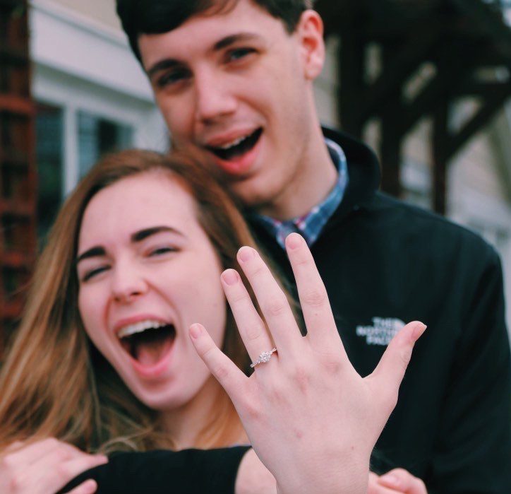 Excited couple with hand showing off engagement ring. Hannah and Michael Engagement Ring Testimonial.